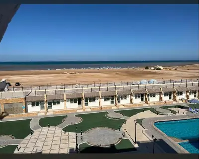 a large building with a swimming pool and a beach at اوسيس مارينا in Hurghada