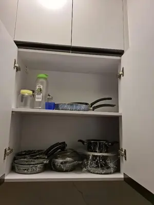 a kitchen pantry with some dishes on a shelf at Cozy flat in Makadi Heights in Hurghada