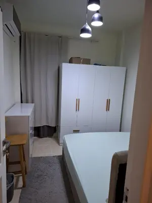 a bedroom with a white bed and white cabinets at Cozy flat in Makadi Heights in Hurghada