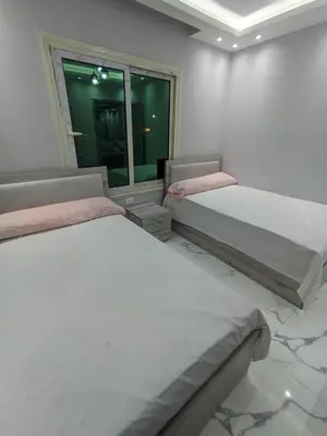 two beds in a room with a window at Avin Resort in Hurghada