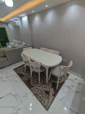 a dining room with a white table and chairs at Avin Resort in Hurghada