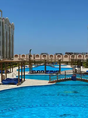 a bridge over a large pool with blue water at Avin Resort in Hurghada