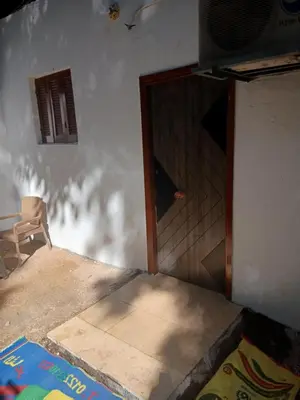 a room with a door and a table and a chair at Sheba Kato in Jazīrat Aswān