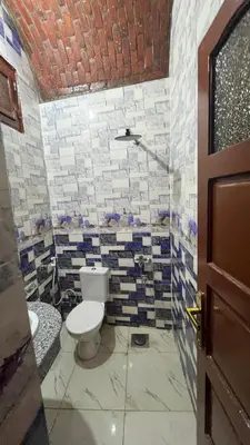 a bathroom with a toilet and a brick wall at Sheba Kato in Jazīrat Aswān
