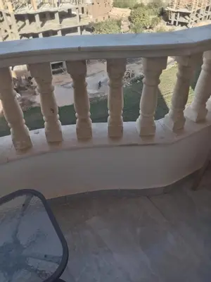 a glass table on a balcony with a view at Luxor Hostel Place in Al Baghdādī