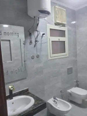 a bathroom with a sink and a toilet and a mirror at Luxor Hostel Place in Al Baghdādī