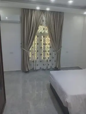 a bedroom with a bed and a window with curtains at Luxor Hostel Place in Al Baghdādī
