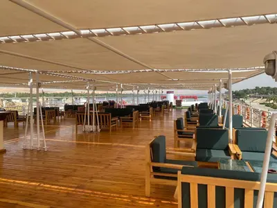 a row of tables and chairs under a tent at nile crouse in Luxor