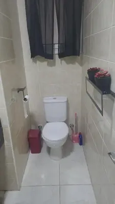 a bathroom with a white toilet in a stall at Hurghada Apartment in Hurghada