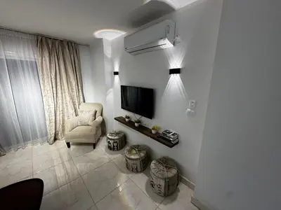 a living room with a television and a chair at Hurghada Apartment in Hurghada