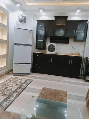 a kitchen with a white refrigerator and black cabinets at flat in Hurghada Sheraton Street in Hurghada