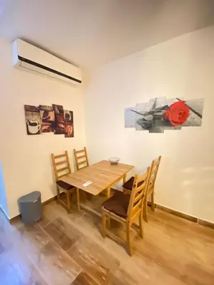 a table and chairs in a room with a painting at florenza Resort - Hurghada Egypt in Hurghada