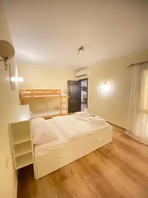 a bedroom with a white bed and a wooden floor at florenza Resort - Hurghada Egypt in Hurghada