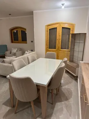 a dining room with a white table and chairs at Pharaohs Apartments - Panoramic Fourth Floor Apartment in Luxor