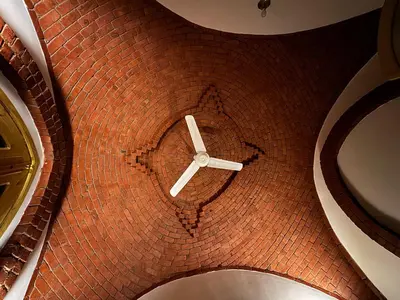 an overhead view of a clock in a brick building at Pharaohs Apartments - Panoramic Fourth Floor Apartment in Luxor