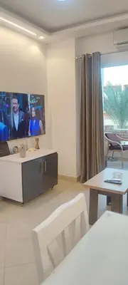 a living room with a tv and a table at Ezz in Hurghada