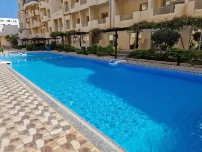 a large blue swimming pool in front of a building at Ezz in Hurghada