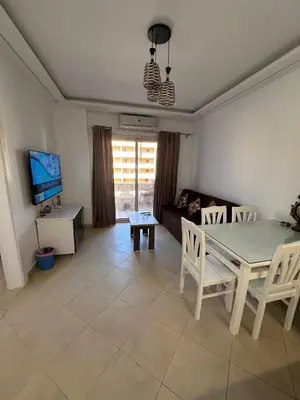 a living room with a table and chairs and a couch at Ezz in Hurghada