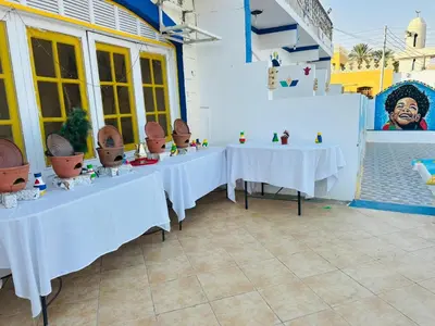 a row of tables with cacti on them in a building at Kuliih guest house in Jazīrat Suhayl