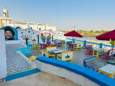 a group of tables and chairs in a water park at Kuliih guest house in Jazīrat Suhayl