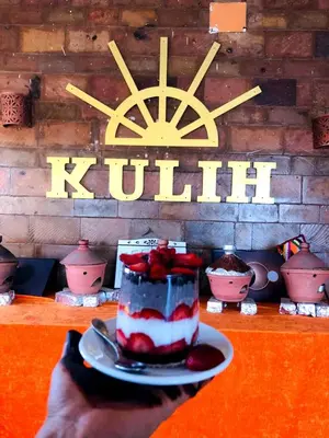 a piece of cake on a plate on a table at Kuliih guest house in Jazīrat Suhayl