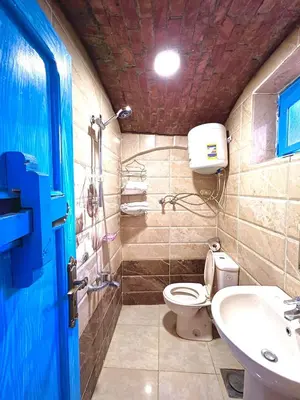 a bathroom with a toilet and a sink at Kuliih guest house in Jazīrat Suhayl