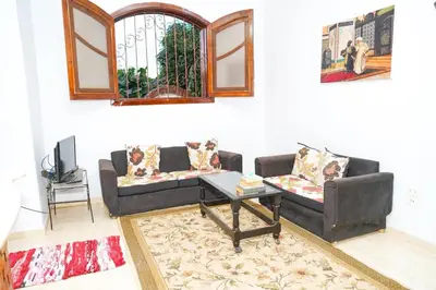 a living room with two couches and a table at Aisha Guest House And Restaurant in Al Aqālitah