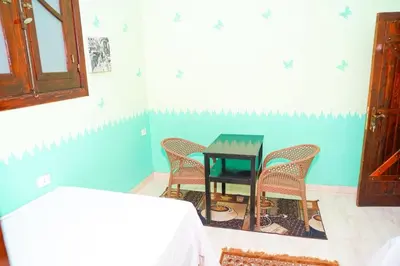 a table and chairs in a room with blue walls at Aisha Guest House And Restaurant in Al Aqālitah
