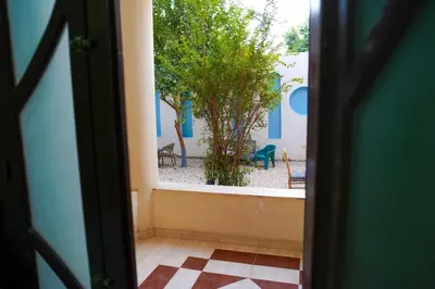 an open door with a view of a yard at Aisha Guest House And Restaurant in Al Aqālitah