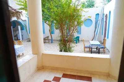 a view of a courtyard with a table and chairs at Aisha Guest House And Restaurant in Al Aqālitah