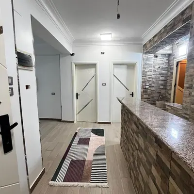 a room with two doors and a stone wall at FUN MBASSY DELUXE APARTMENT ASWAN down town in Aswan