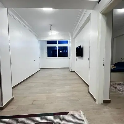 an empty hallway with white walls and a window at FUN MBASSY DELUXE APARTMENT ASWAN down town in Aswan