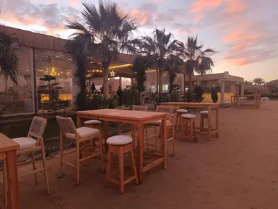 a group of tables and chairs and palm trees at Selena Bay in Hurghada