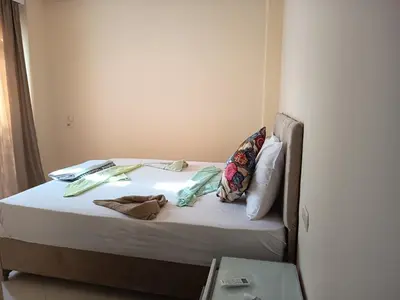 a bed with white sheets and pillows in a room at Karima's house B in Al Aqālitah