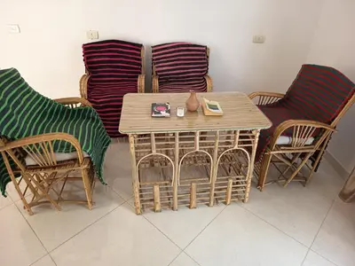 a table and chairs in a room with a table and chairs at Karima's house B in Al Aqālitah
