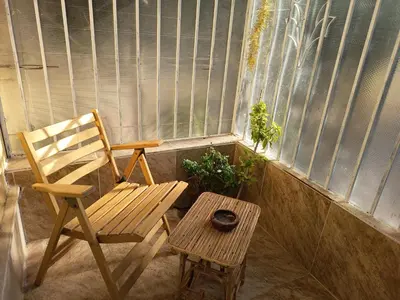 a chair and a table in front of a window at Karima's house B in Al Aqālitah
