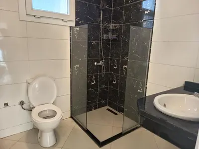 a bathroom with a toilet and a sink at Karima's house B in Al Aqālitah