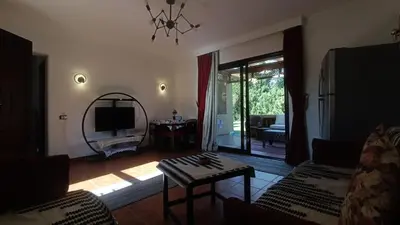 a living room with a couch and a table at Cozy Chalet In Stella Makadi Beach Resort Hurghada in Hurghada