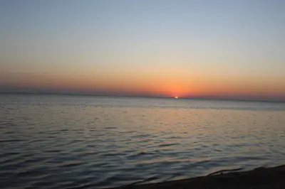 a sunset over a body of water at Cozy Chalet In Stella Makadi Beach Resort Hurghada in Hurghada