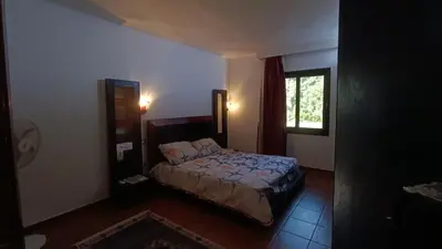 a bedroom with a bed and a window at Cozy Chalet In Stella Makadi Beach Resort Hurghada in Hurghada