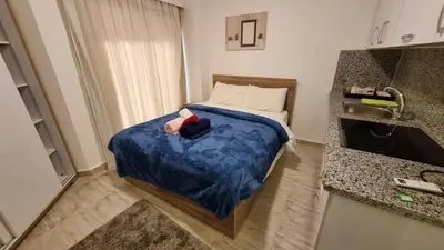 a small room with a bed with a blue blanket at Aqua Palms Resort Hurghada in Hurghada