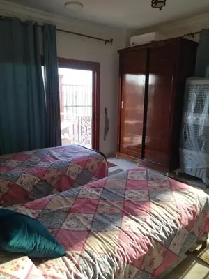 a bedroom with a bed and a large window at Luxor Resort in Al Bayāḑīyah
