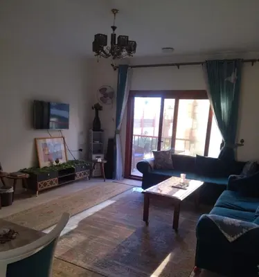a living room with blue couches and a table at Luxor Resort in Al Bayāḑīyah