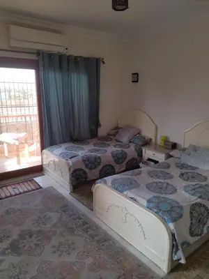a bedroom with three beds and a window with a patio at Luxor Resort in Al Bayāḑīyah