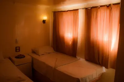 a small bedroom with two beds and a window at Water Lily in Luxor