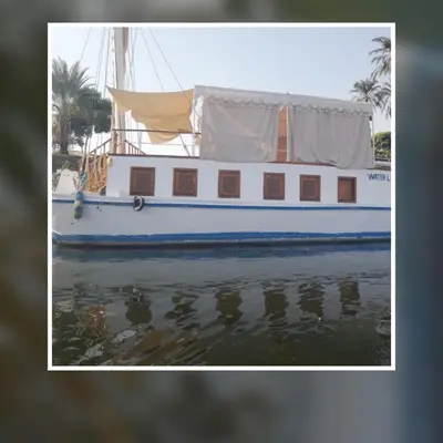 a boat sitting in the water with its reflection in the water at Water Lily in Luxor