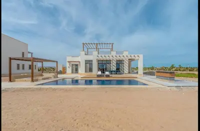 a house with a swimming pool in front of it at Stunning Villa with breathtaking golf & lake view in Hurghada