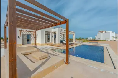 a villa with a swimming pool and a house at Stunning Villa with breathtaking golf & lake view in Hurghada