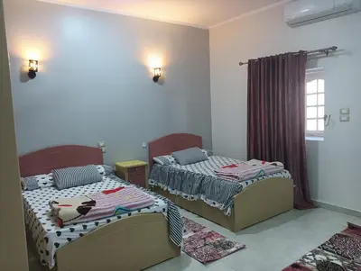two beds sitting in a room with a window at noreno house in Shellal