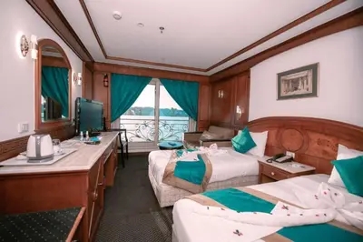 a train room with two beds and a television at فندق نايل ستوري سوهاج in Suwhaj